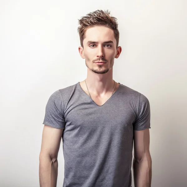 Ung vacker man i grå t-shirt. — Stockfoto