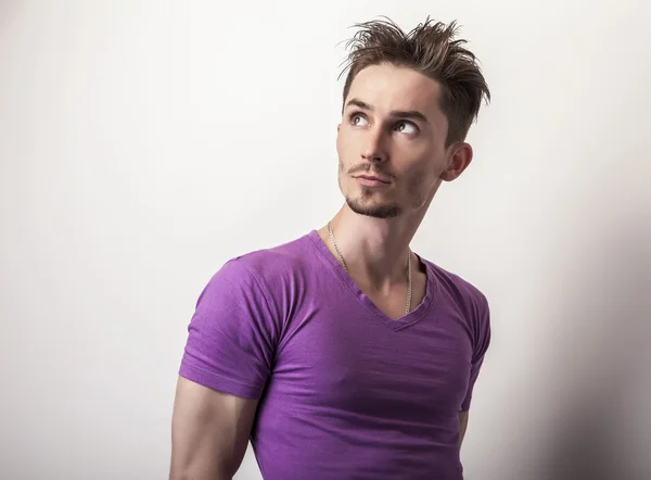 Młody przystojny mężczyzna w fioletowy t-shirt. — Zdjęcie stockowe