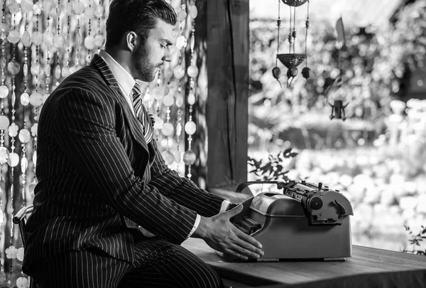 Joven hombre de moda cerca de la vieja máquina de escribir . — Foto de Stock