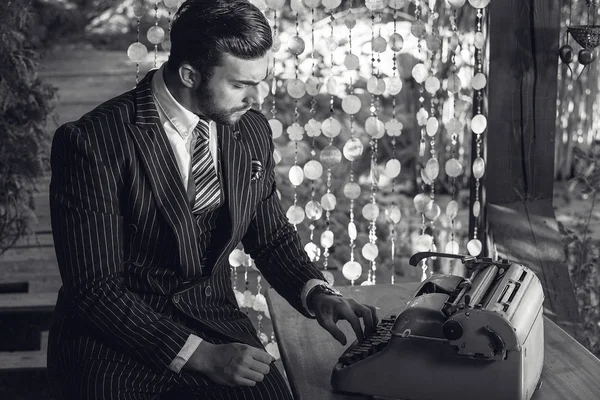 Giovane uomo alla moda vicino alla vecchia macchina da scrivere . — Foto Stock