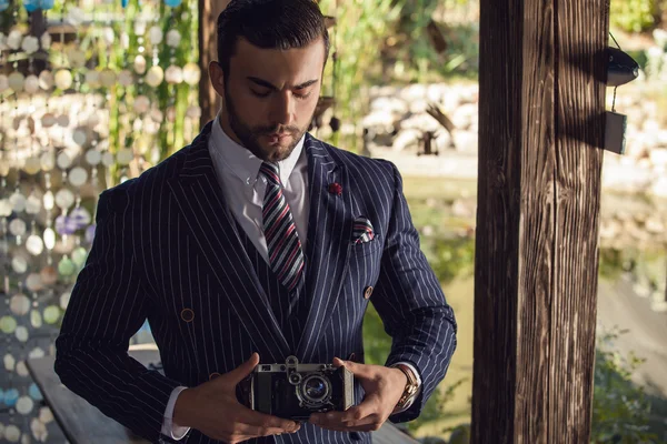 Giovane uomo alla moda con fotocamera retrò . — Foto Stock