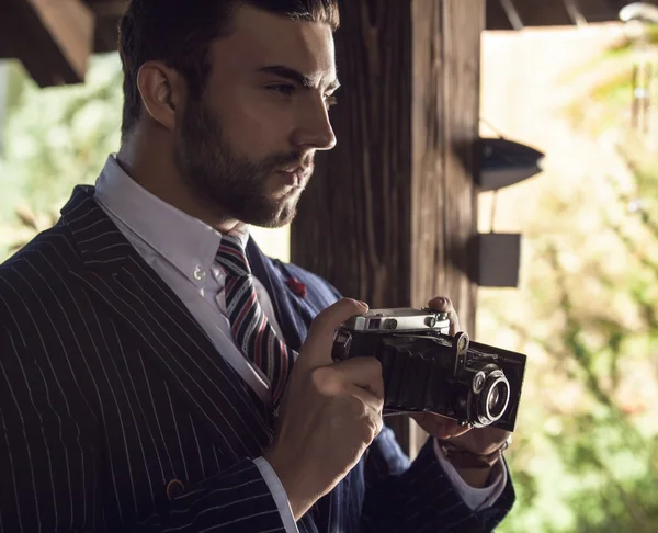 Jovem homem elegante com câmera retro . — Fotografia de Stock