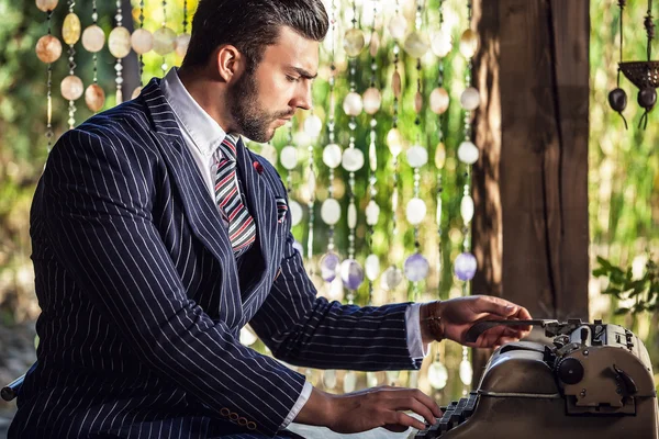 Fashionable man near old typewriter. — Stock Photo, Image