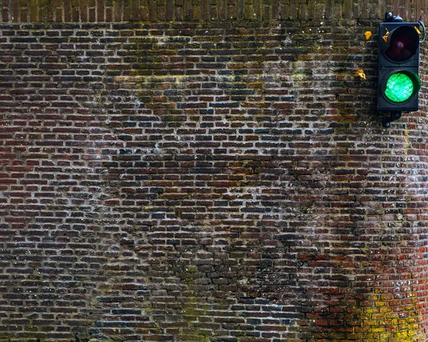Antiguo muro de ladrillo con semáforo — Foto de Stock