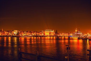 AMSTERDAM, NETHERLANDS - JANUARY 1, 2016: General view on night canal in center of Amsterdam from bridge near museum Nemo. On January 1, 2016 in Amsterdam - Netherland.