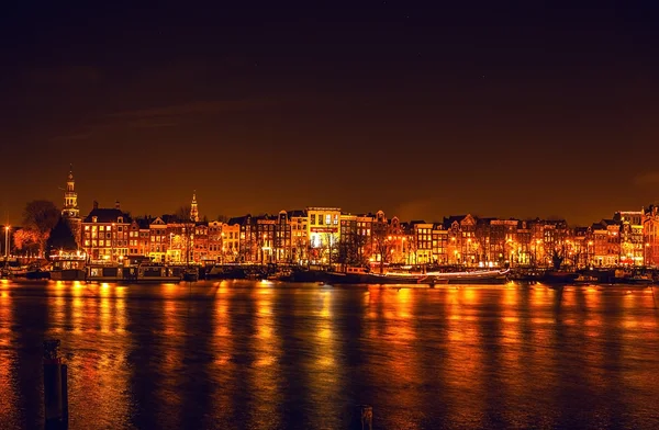 AMSTERDAM, PAYS-BAS - 1er JANVIER 2016 : Vue générale sur le canal nocturne dans le centre d'Amsterdam depuis le pont près du musée Nemo. Le 1er janvier 2016 à Amsterdam - Pays-Bas . — Photo