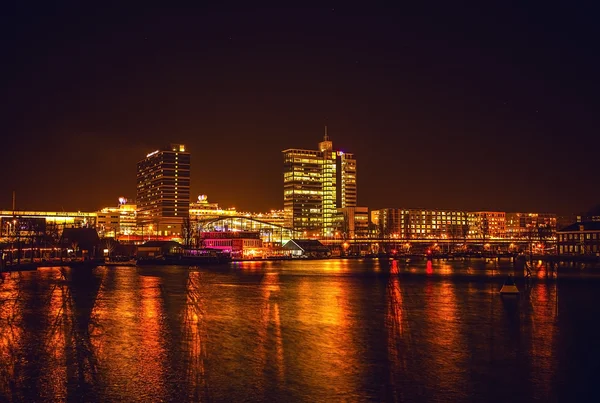 AMSTERDAM, PAÍSES BAJOS - 1 DE ENERO DE 2016: Vista general del canal nocturno en el centro de Ámsterdam desde el puente cerca del museo Nemo. El 1 de enero de 2016 en Amsterdam - Países Bajos . —  Fotos de Stock