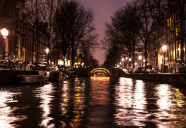Gece aydınlatma yansımaları hareket eden Amsterdam kanallarında tekne gezisi. Arka plan olarak bulanık soyut fotoğraf.