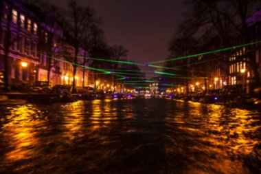 Gece aydınlatma yansımaları hareket eden Amsterdam kanallarında tekne gezisi. Arka plan olarak bulanık soyut fotoğraf.