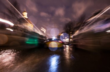 Gece aydınlatma yansımaları hareket eden Amsterdam kanallarında tekne gezisi. Arka plan olarak bulanık soyut fotoğraf.
