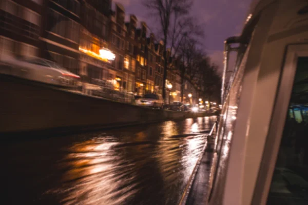 Reflexos de iluminação noturna em canais de Amsterdã de barco de cruzeiro em movimento. Foto abstrata borrada como fundo . — Fotografia de Stock