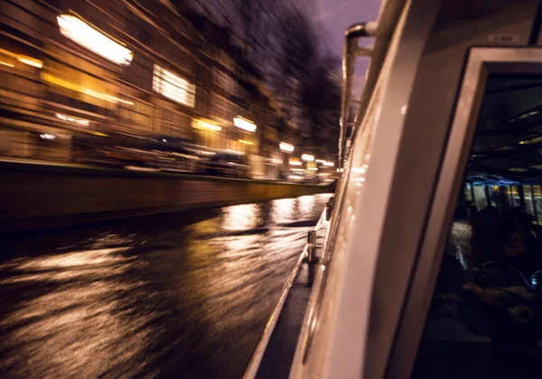 Night lighting reflections in Amsterdam channels from moving cruise boat. Blurred abstract photo as background. — Stock Photo, Image
