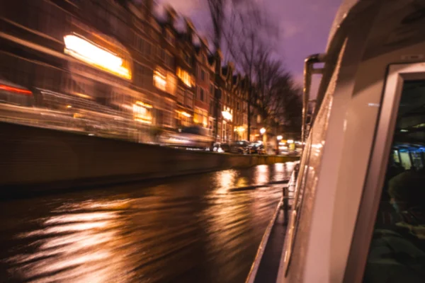 Noční osvětlení odrazy v amsterdamské kanály z pohybu výletní lodi. Rozmazané abstraktní fotografie jako pozadí. — Stock fotografie