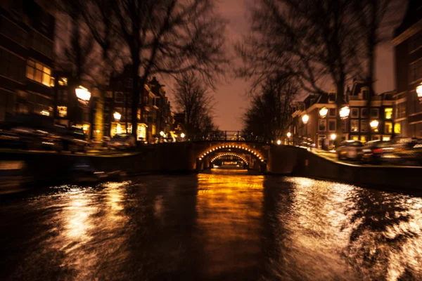 Riflessioni di illuminazione notturna nei canali di Amsterdam da barca da crociera in movimento. Foto astratta offuscata come sfondo . — Foto Stock