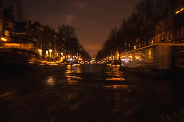 Gece aydınlatma yansımaları hareket eden Amsterdam kanallarında tekne gezisi. Arka plan olarak bulanık soyut fotoğraf. — Stok fotoğraf