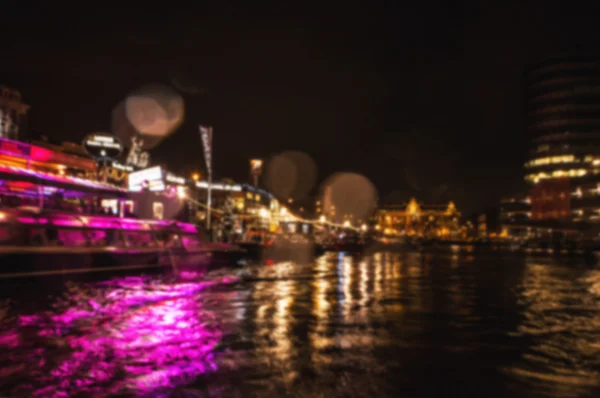 Nacht verlichting reflecties in Amsterdam kanalen verplaatsen cruise boot. Wazig abstracte foto als achtergrond. — Stockfoto