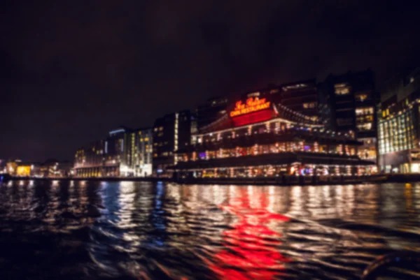 Natt belysning reflektioner i Amsterdams kanaler från att flytta kryssning båt. Suddig abstrakt foto som bakgrund. — Stockfoto
