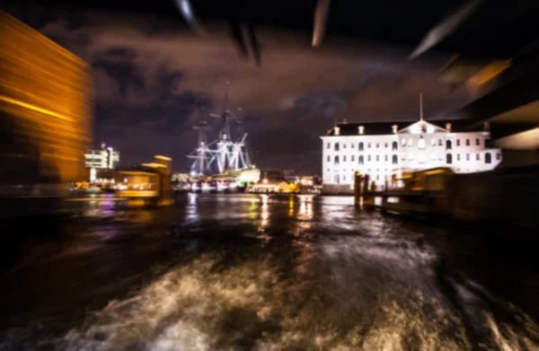 Nachtbeleuchtung Reflexionen in Amsterdam Kanäle aus beweglichen Kreuzfahrtschiff. verschwommenes abstraktes Foto als Hintergrund. — Stockfoto