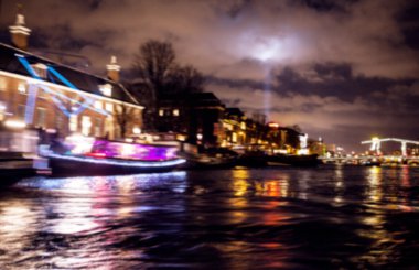 Gece aydınlatma yansımaları hareket eden Amsterdam kanallarında tekne gezisi. Arka plan olarak bulanık soyut fotoğraf.