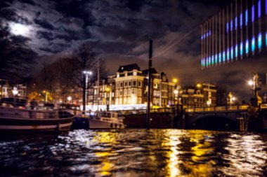 Gece aydınlatma yansımaları hareket eden Amsterdam kanallarında tekne gezisi. Arka plan olarak bulanık soyut fotoğraf.