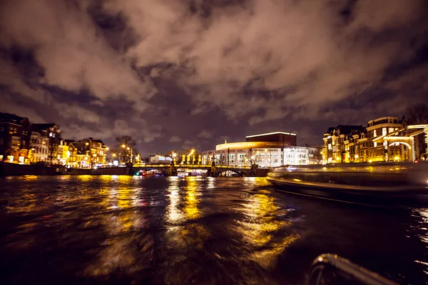 Réflexions d'éclairage nocturne dans les canaux Amsterdam de bateau de croisière en mouvement. Photo abstraite floue comme arrière-plan . — Photo