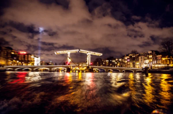 Réflexions d'éclairage nocturne dans les canaux Amsterdam de bateau de croisière en mouvement. Photo abstraite floue comme arrière-plan . — Photo