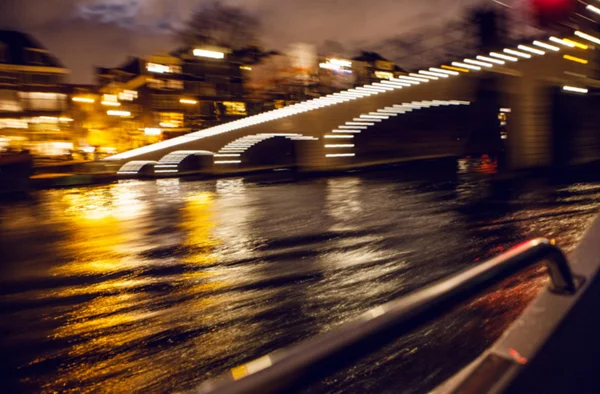 Night lighting reflections in Amsterdam channels from moving cruise boat. Blurred abstract photo as background. — Stock Photo, Image