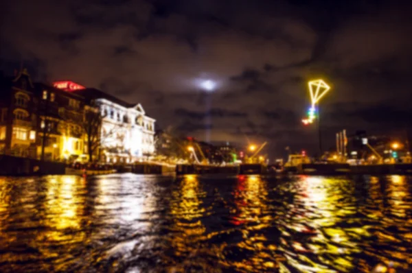 Nacht verlichting reflecties in Amsterdam kanalen verplaatsen cruise boot. Wazig abstracte foto als achtergrond. — Stockfoto