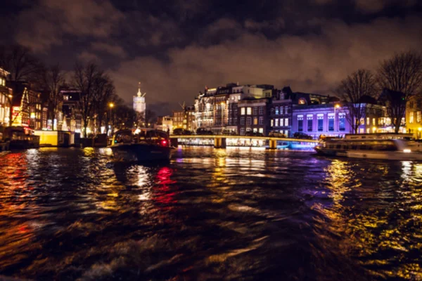 Reflejos de iluminación nocturna en los canales de Amsterdam desde el crucero en movimiento. Foto abstracta borrosa como fondo . — Foto de Stock