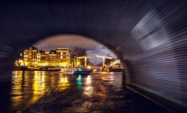 Nacht verlichting reflecties in Amsterdam kanalen verplaatsen cruise boot. Wazig abstracte foto als achtergrond. — Stockfoto