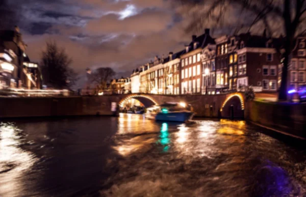 Nacht verlichting reflecties in Amsterdam kanalen verplaatsen cruise boot. Wazig abstracte foto als achtergrond. — Stockfoto