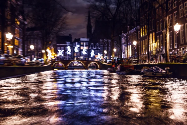 Reflejos de iluminación nocturna en los canales de Amsterdam desde el crucero en movimiento. Foto abstracta borrosa como fondo . — Foto de Stock