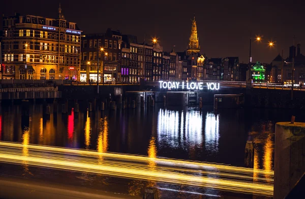 Barca da crociera con luce sfocata in movimento sui canali notturni di Amsterdam . — Foto Stock