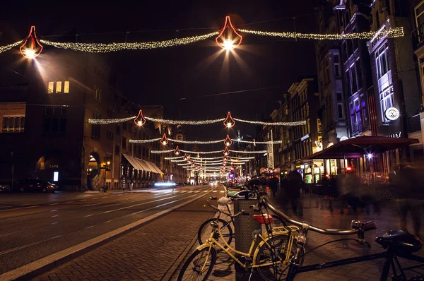 AMSTERDAM, NETHERLANDS - JANUARY 20, 2016: Night streets of Amsterdam with blurred silhouettes of passersby on January 20, 2016 in Amsterdam - Netherland. — Stock Fotó