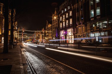 Headlights car passing down street in night Amsterdam.