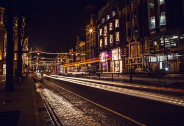Headlights car passing down street in night Amsterdam.