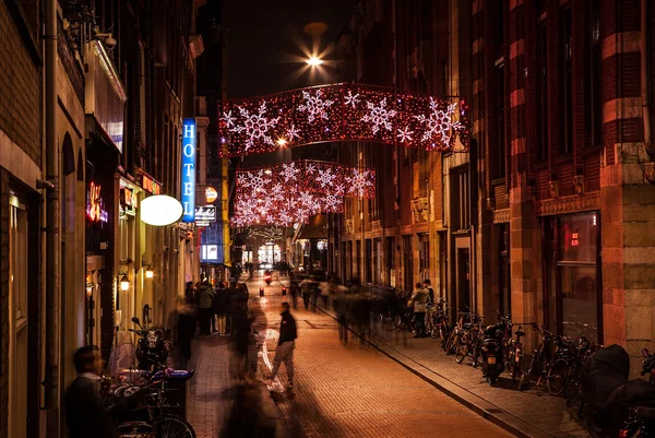 Night streets of Amsterdam with blurred silhouettes of passersby. — Stock Fotó