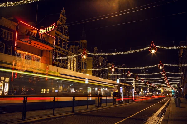 Night streets of Amsterdam with blurred silhouettes of tram. — Stock Fotó