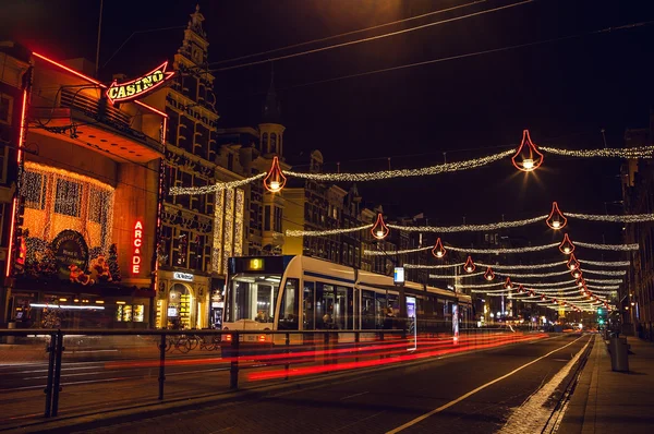 Strade notturne di Amsterdam con sagome sfocate di tram . — Foto Stock