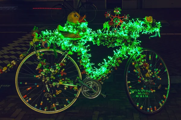 Bicycle with brightly green illumination & decorative elements at night time. — Stock fotografie