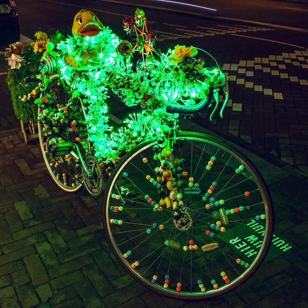 Bicycle with brightly green illumination & decorative elements at night time. — Stock fotografie
