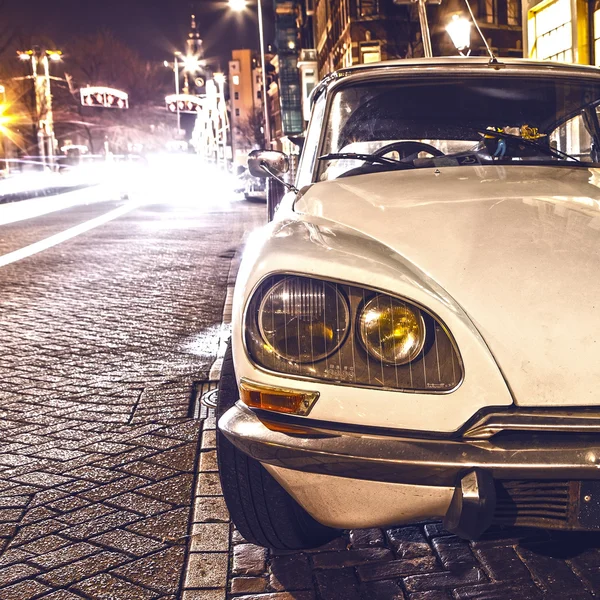 Vintage white car parked in center of Amsterdam at night time. — Stock Photo, Image