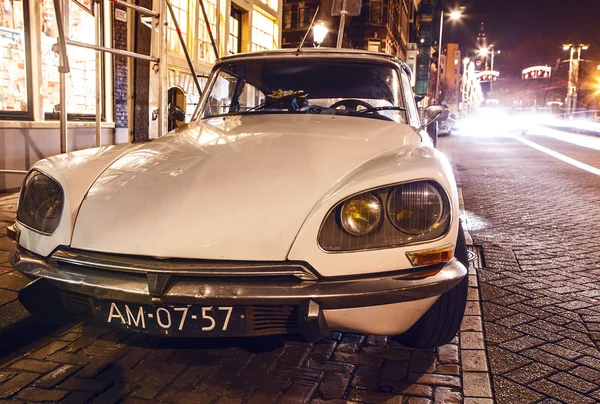 AMSTERDÃO, PAÍSES BAIXOS - JANEIRO 5, 2016: Carro branco vintage estacionado no centro de Amesterdão à noite. 5 de janeiro de 2016 em Amsterdã - Holanda . — Fotografia de Stock