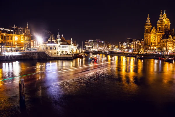 Výletní loď s rozostření se světlo v noci kanály Amsterdamu. — Stock fotografie