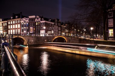 Amsterdam gece kanalları üzerinde hareket bulanıklığı ışık ile mavi yolculuk.
