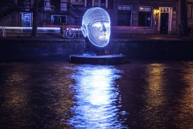 AMSTERDAM, NETHERLANDS - DECEMBER 19, 2015: Light installations on night canals of Amsterdam within light festival on December 19, 2015 in Amsterdam - Netherland. clipart