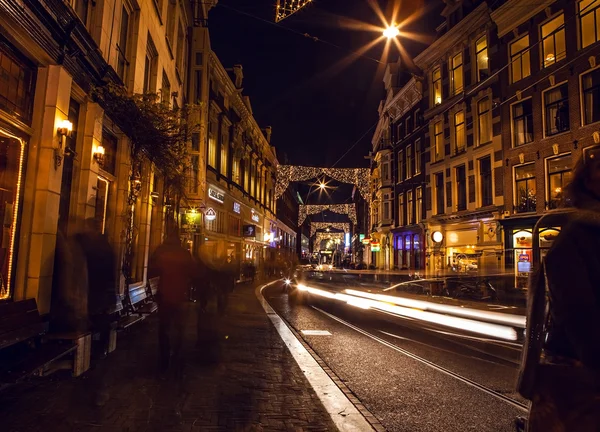 Headlights car passing down street in night Amsterdam. — Stockfoto