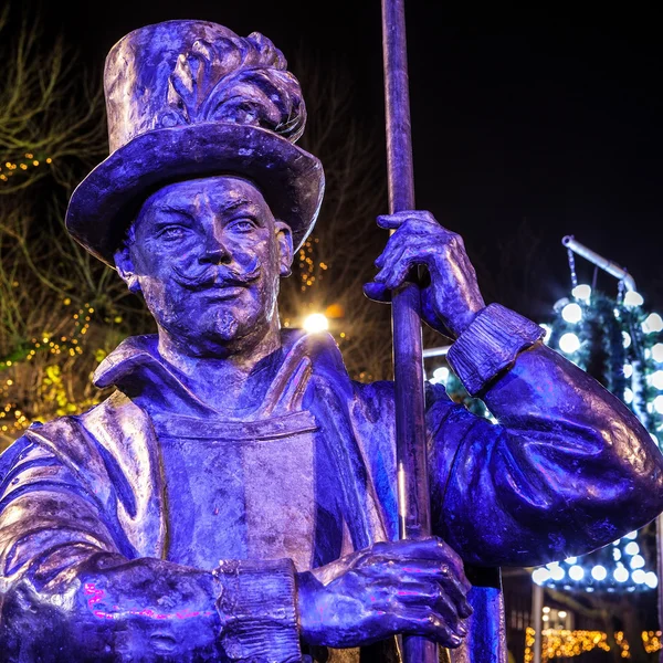 AMSTERDAM, NETHERLANDS - DECEMBER 19, 2015: Bronze figures of soldiers on central square of city lit with street light at night on December 19, 2015 in Amsterdam - Netherland. — Stockfoto