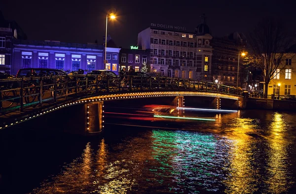 Bateau de croisière avec lumière floue se déplaçant sur les canaux de nuit d'Amsterdam . — Photo
