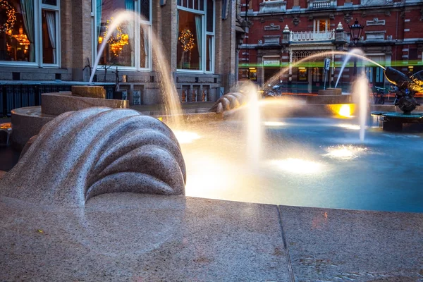 Fuente antigua con iluminación en el crepúsculo . — Foto de Stock